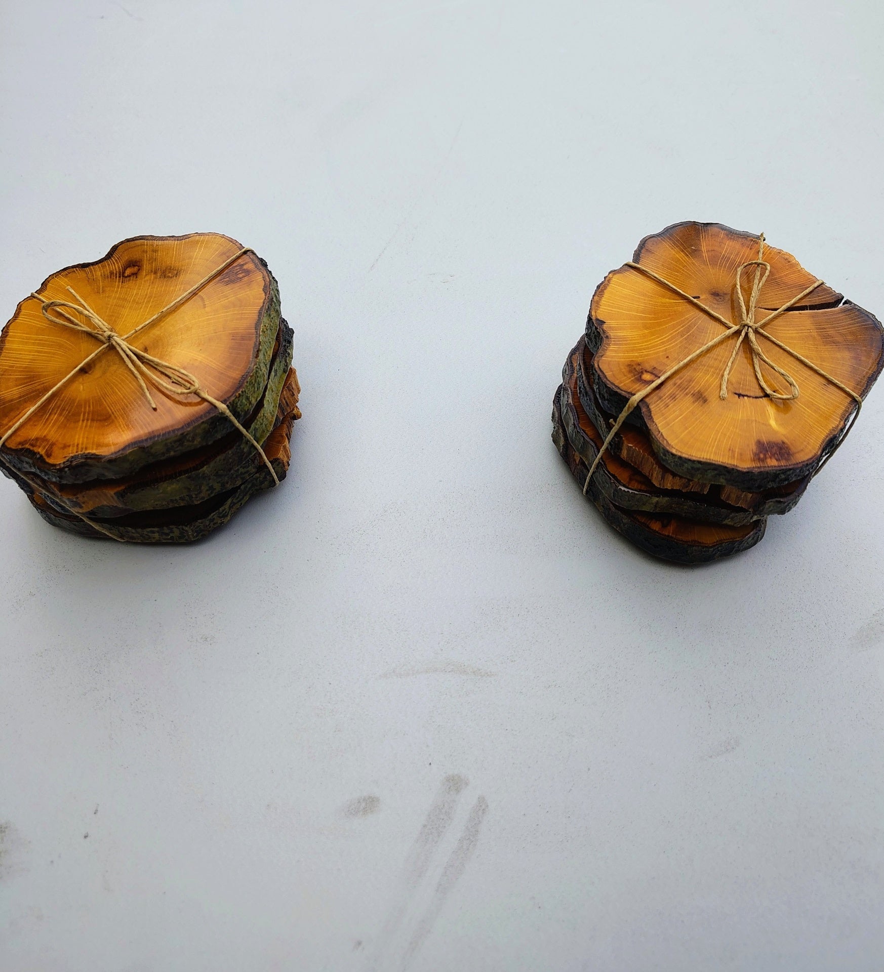 Two stacks of live edge wood coasters tied with twine