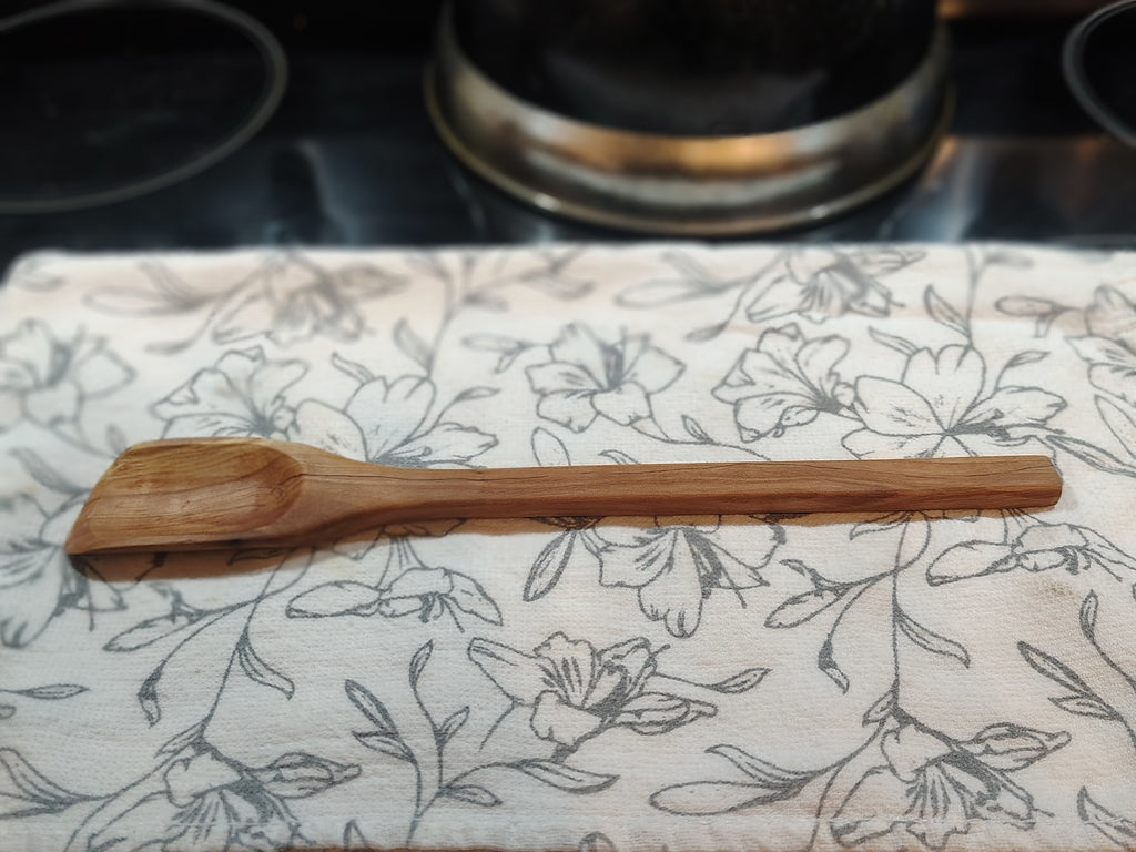 Hand-carved small roux spoon on towel